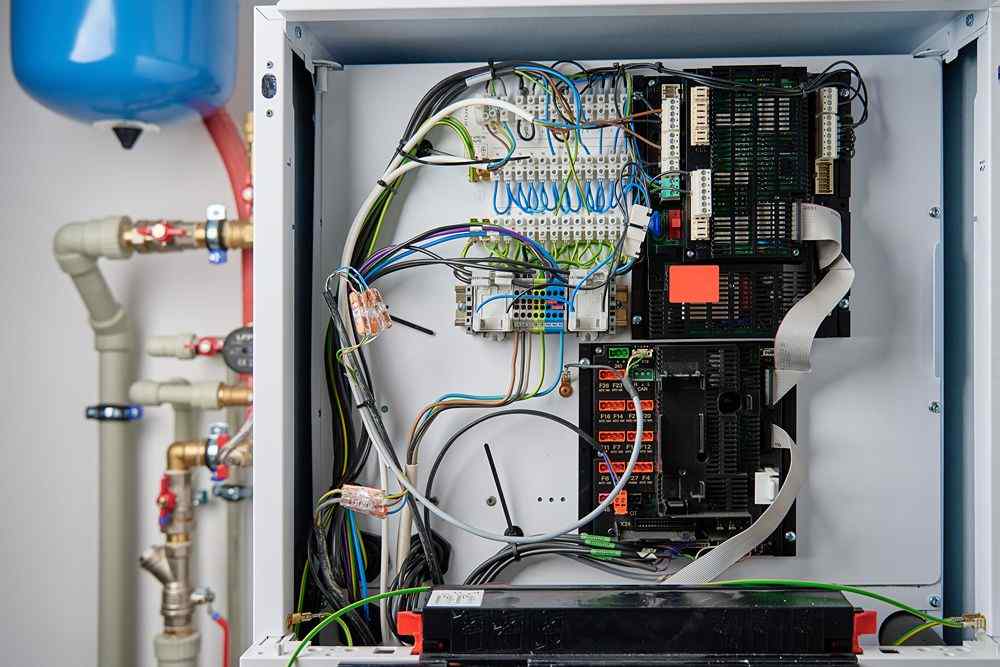 Elektrik kontrol panosunun içi, kablolar ve devre kartlarıyla birlikte açık halde görünüyor