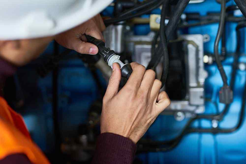 Pursaklar Viessmann Servisi  teknisyeni, mavi bir makinenin içindeki kablo bağlantısını yapıyor