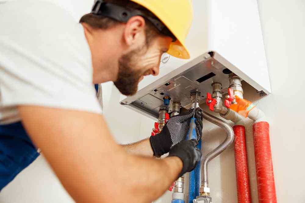 Kombi kazanını kontrol eden tesisatçı