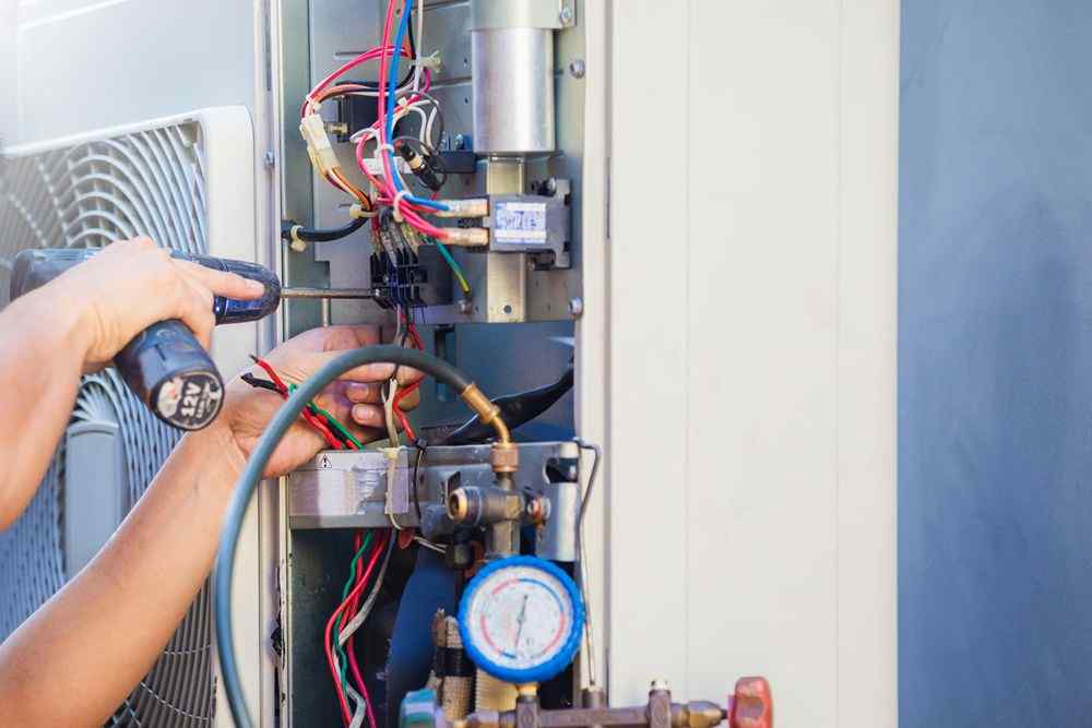 pursaklar vaillant servisi teknisyeni, klima ünitesinin iç aksamını tornavidayla onarıyor