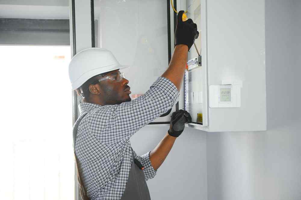 Elektrik panosunu kontrol eden işçi