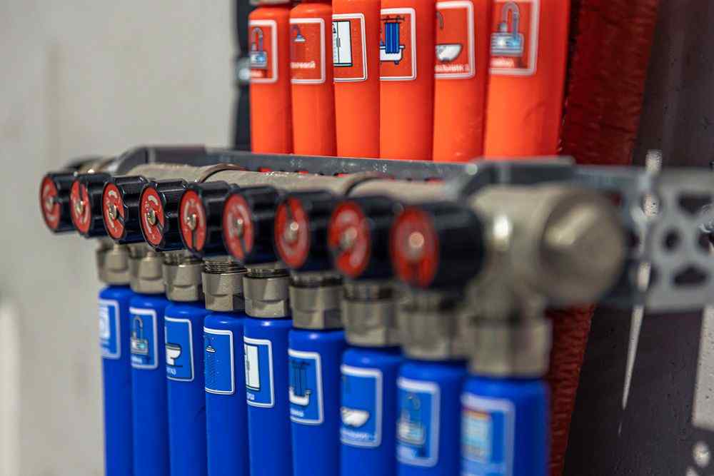 Mavi ve turuncu gaz tüplerinin bağlı olduğu bir manifold sistemi