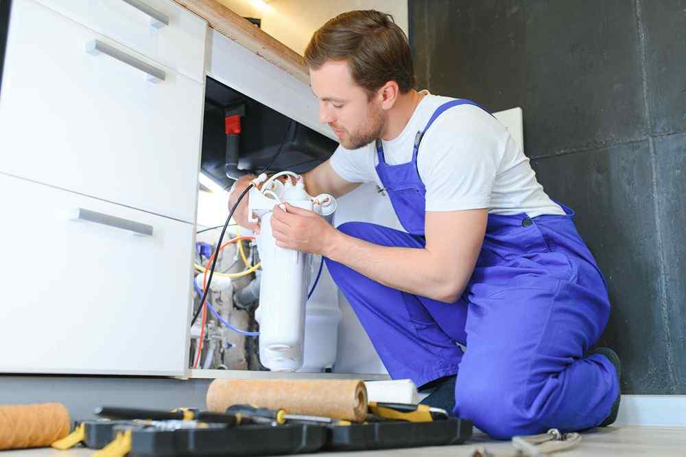 Mutfak dolabının altındaki su filtresini tamir eden Mamak Ferroli Servisi tesisatçısı