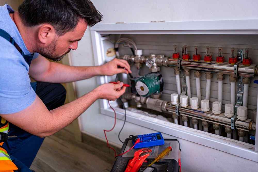 Isıtma sisteminin kollektörünü multimetreyle kontrol eden Keçiören Bosch Servisi teknisyeni