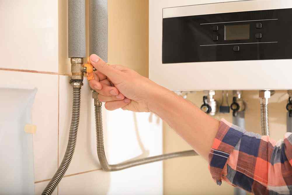 Kombi kazanının gaz vanasını kapatan el