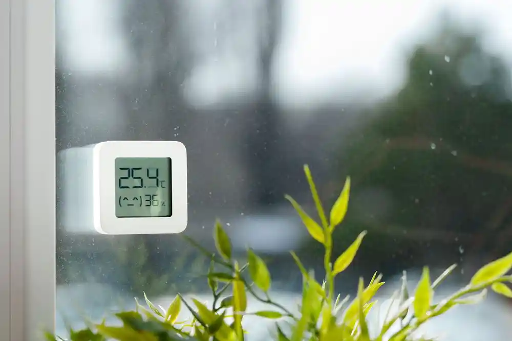 Pencere önündeki dijital termometre 25,4 °C sıcaklık ve nem gösteriyor