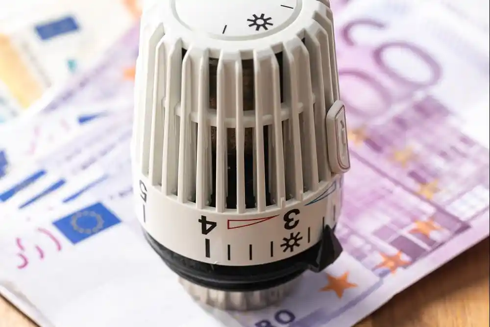 Euro banknotlarının üzerinde duran bir radyatör termostatı