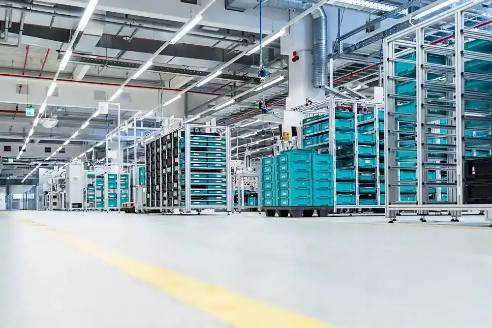 atlas (240) Turkuaz kutularla dolu rafların bulunduğu modern bir üretim veya lojistik tesisi