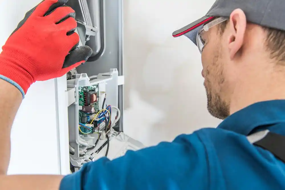 atlas (370) Bir teknisyen, eldivenleriyle açık bir elektrik panosundaki kabloları ve devre kartını inceliyor