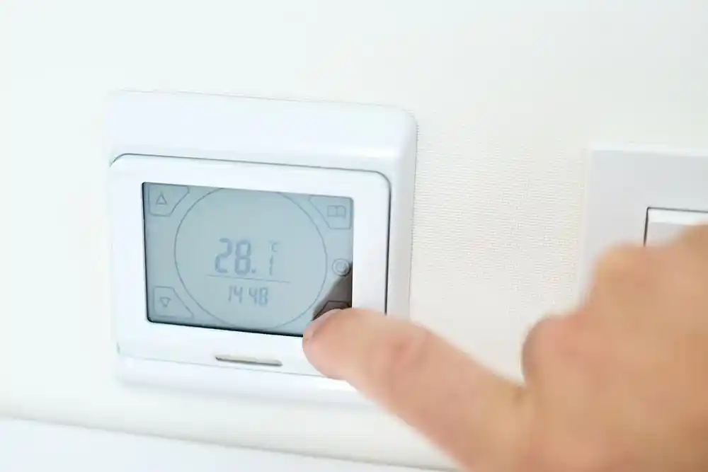 Parmakla ayarlanan termostatın ekranında 28 °C ve 14:48 gösteriliyor