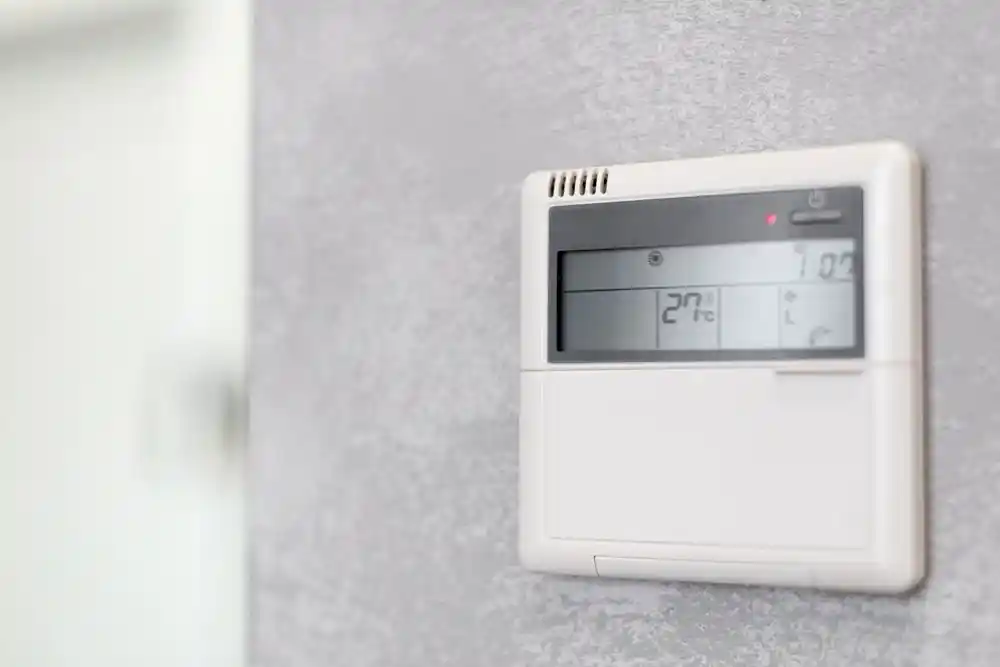 Duvardaki dijital termostatın ekranında 20°C yazıyor