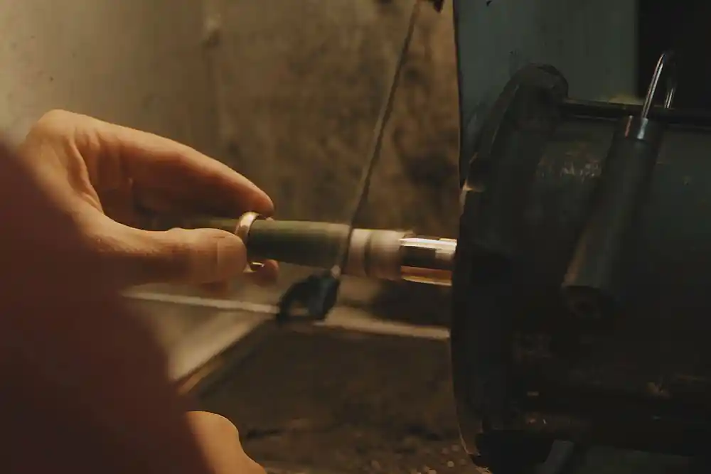 Bir el, elektrikli matkabın ucuna takılı silindirik parçayı tutuyor