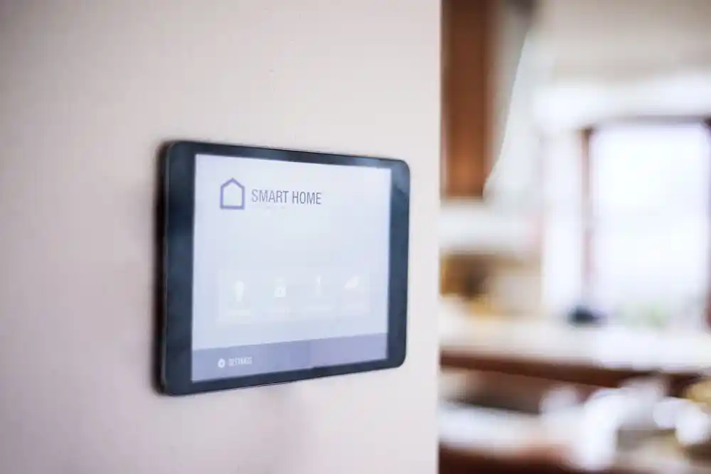 Duvara monte edilmiş, üzerinde “SMART HOME” yazan akıllı ev kontrol paneli