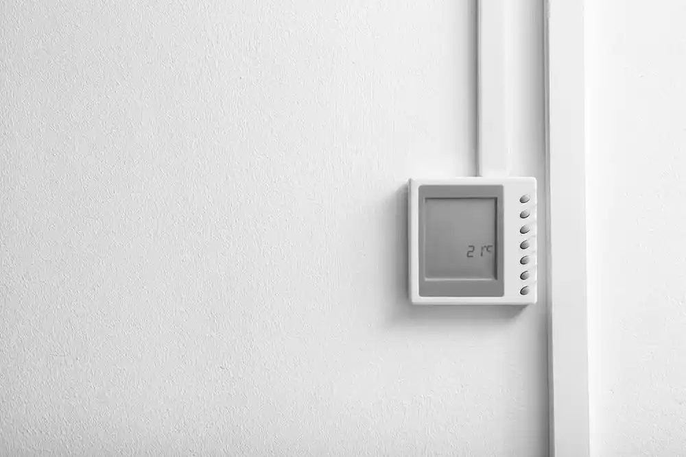 Duvara monte dijital termostatın ekranında 21 °C gösteriliyor