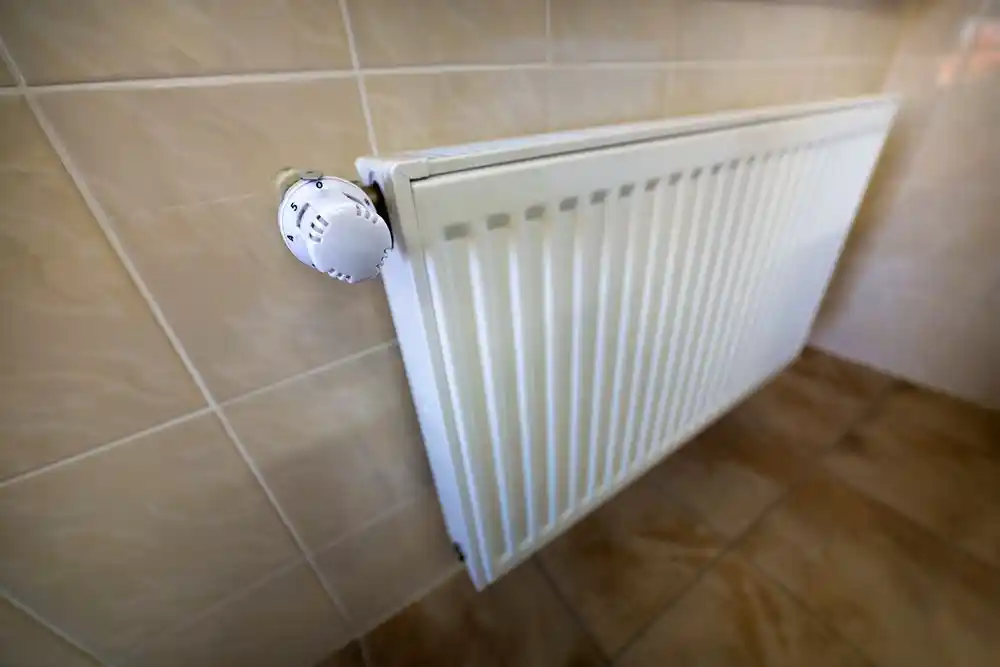 Duvara monte beyaz panel radyatör ve sıcaklık ayar düğmesi