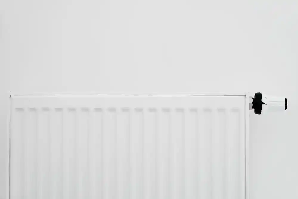 Beyaz panel radyatör ve sağ tarafındaki termostat vanası